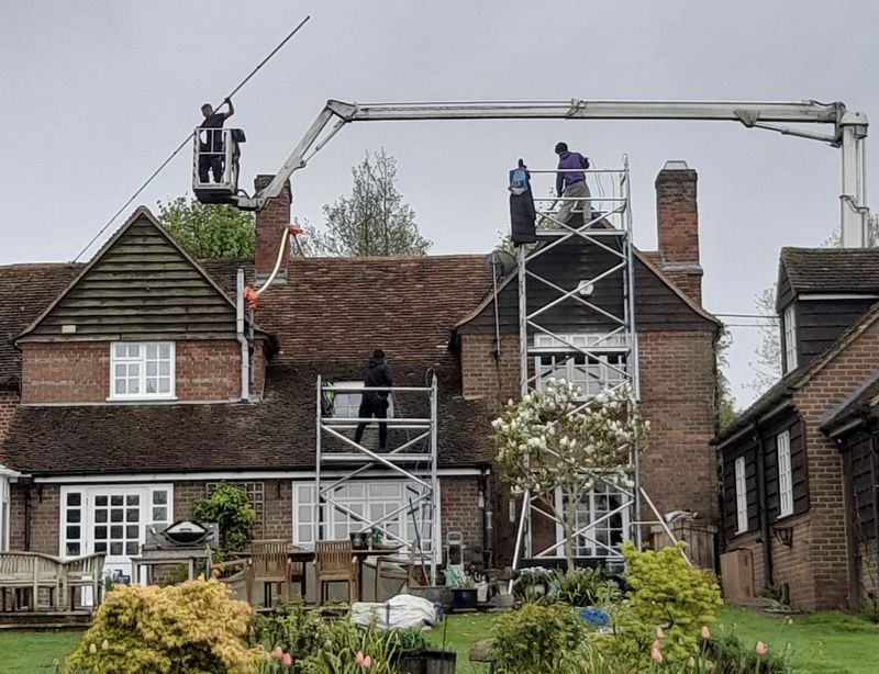 The Moss Cleaners using cherry picker and scaffolding to clean roof safely and professionally in West Chiltington Common, West Sussex